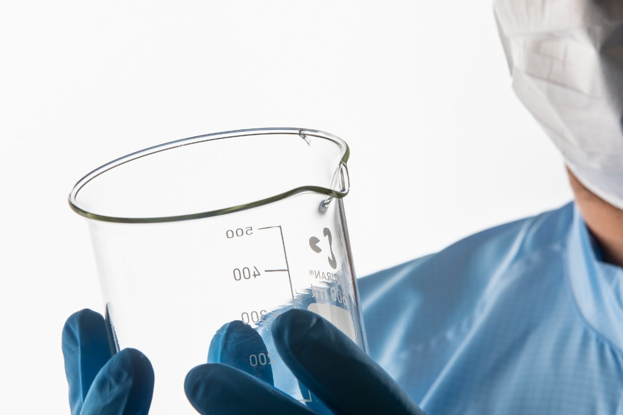 Científico inspeccionando material de vidrio de laboratorio